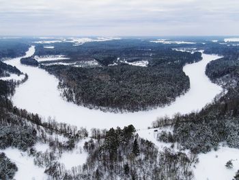 Aerial view of snow covered land and trees against sky