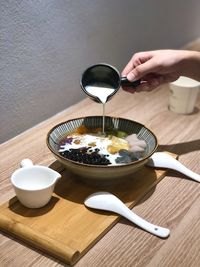 Low angle view of person pouring coffee in cup on table