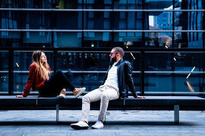 Woman sitting on seat in city