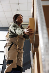 Side view of young woman standing by railing