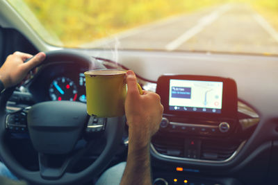 Midsection of man holding coffee cup