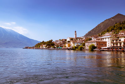 Scenic view of sea by buildings in town against sky