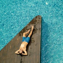 High angle view of man lying on poolside