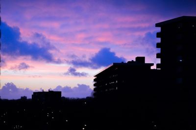 Low angle view of buildings against sky at sunset