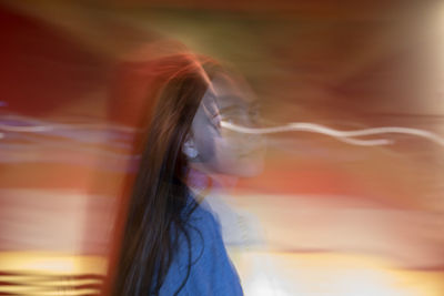 Digital composite image of woman and light trails