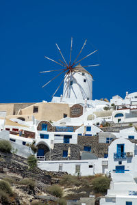 Panoramic view of oia town in santorini island with old whitewashed houses and traditional windmill