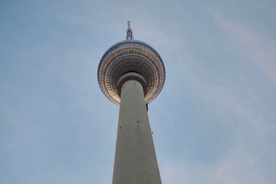 Low angle view of communications tower in city against sky