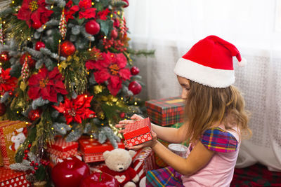 Full length of girl holding christmas tree