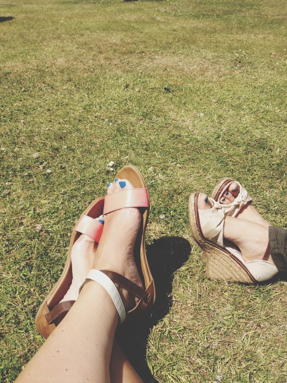 low section, person, grass, lifestyles, relaxation, leisure activity, sitting, resting, relaxing, shoe, grassy, personal perspective, field, lying down, human foot, togetherness, outdoors