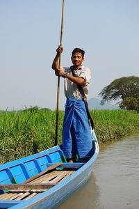 Portrait of man standing against blue sky