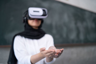Woman wearing virtual reality simulator holding crystal ball