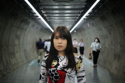 Portrait of woman standing against wall