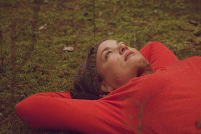 Close-up of woman lying on grassy field