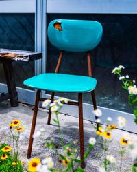Empty chair by flowers