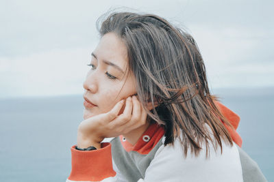 Close-up of thoughtful woman with hand on chin