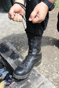 Low section of man tying shoelace on floor