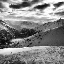 Snow covered landscape against clouds