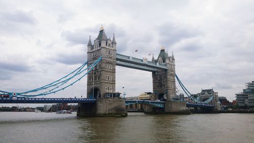 View of bridge over river against cloudy sky