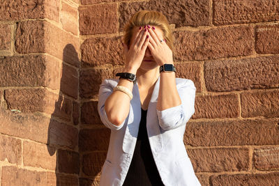 Midsection of woman standing against wall