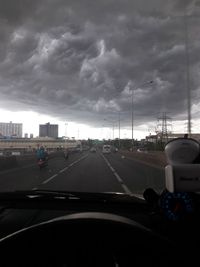 Cars on road against sky seen through car windshield