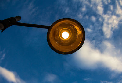 Low angle view of illuminated street light against sky