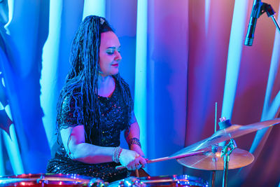 Woman playing drum at music concert