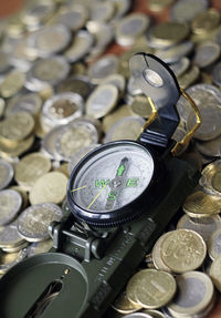 Close-up of navigational compass and coins