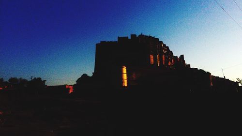 Silhouette buildings against sky during sunset