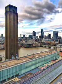 View of skyscrapers in city against cloudy sky