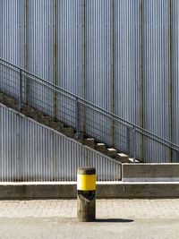Yellow railing on footpath by street