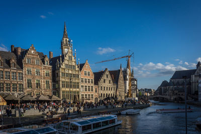 Buildings in city against blue sky