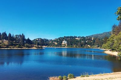 Scenic view of lake against clear blue sky