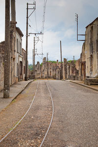 Railroad tracks amidst buildings in city against sky