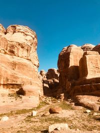 Low angle view of rock formation against clear blue sky
