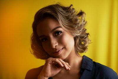 Close-up portrait of woman against colored background