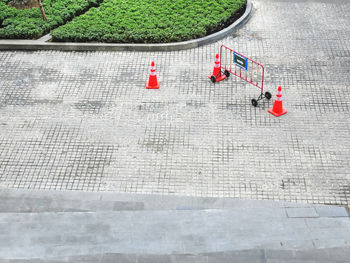 High angle view of portable metal fence and traffic road cones