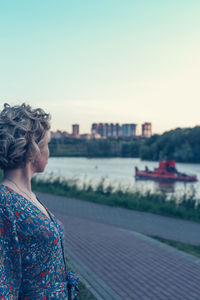 Man looking at river against clear sky
