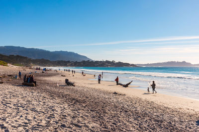 Scenic view of beach with people during sunset