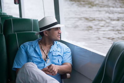 Man sitting in ship while looking out of window