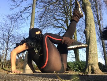 Woman wearing sunglasses on tree trunk