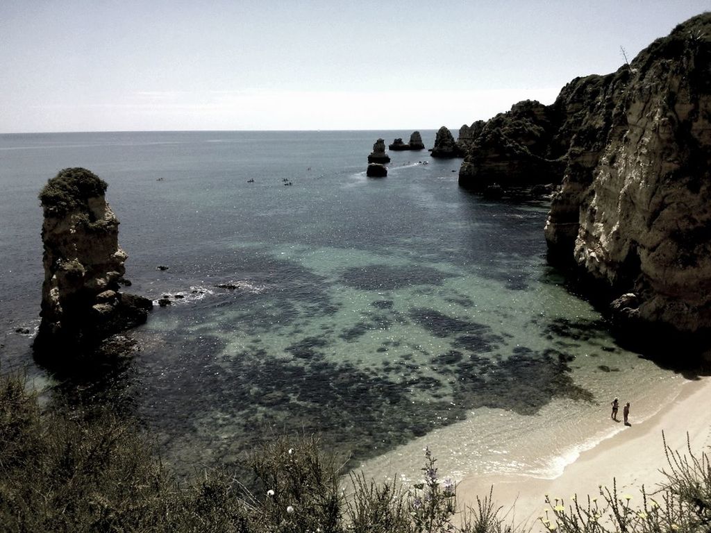 sea, water, horizon over water, beach, tranquility, tranquil scene, scenics, shore, beauty in nature, nautical vessel, nature, rock - object, clear sky, coastline, rock formation, sky, idyllic, transportation, boat, cliff