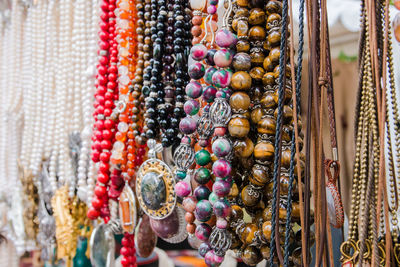 Close-up of necklaces hanging in market for sale