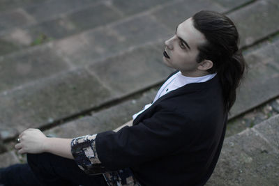 High angle view of thoughtful young man sitting on steps 