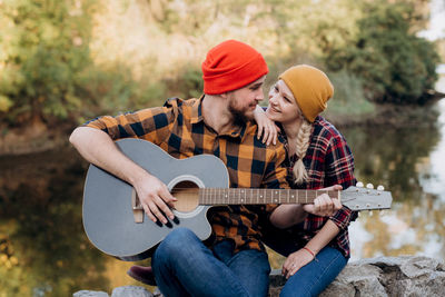 Full length of a young man playing guitar
