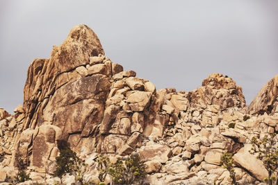 Low angle view of rocky mountain against sky