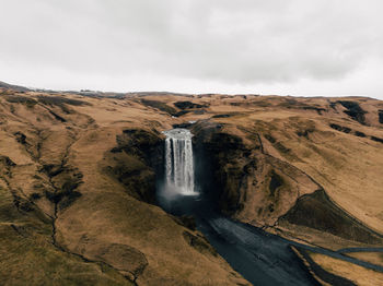 Scenic view of waterfall against sky