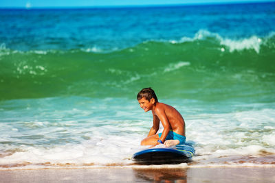 Shirtless man swimming in sea