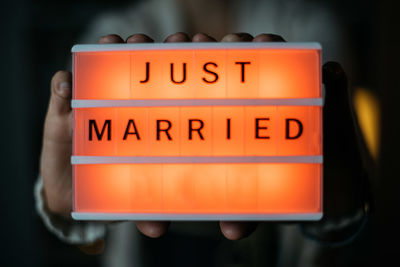 Close-up of hand holding illuminated text