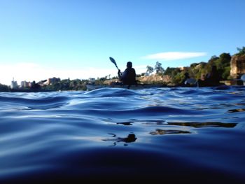 Man in river against clear blue sky