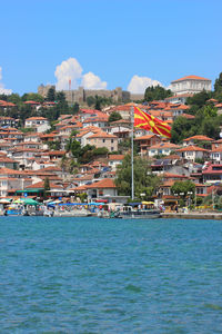 Townscape by sea against blue sky